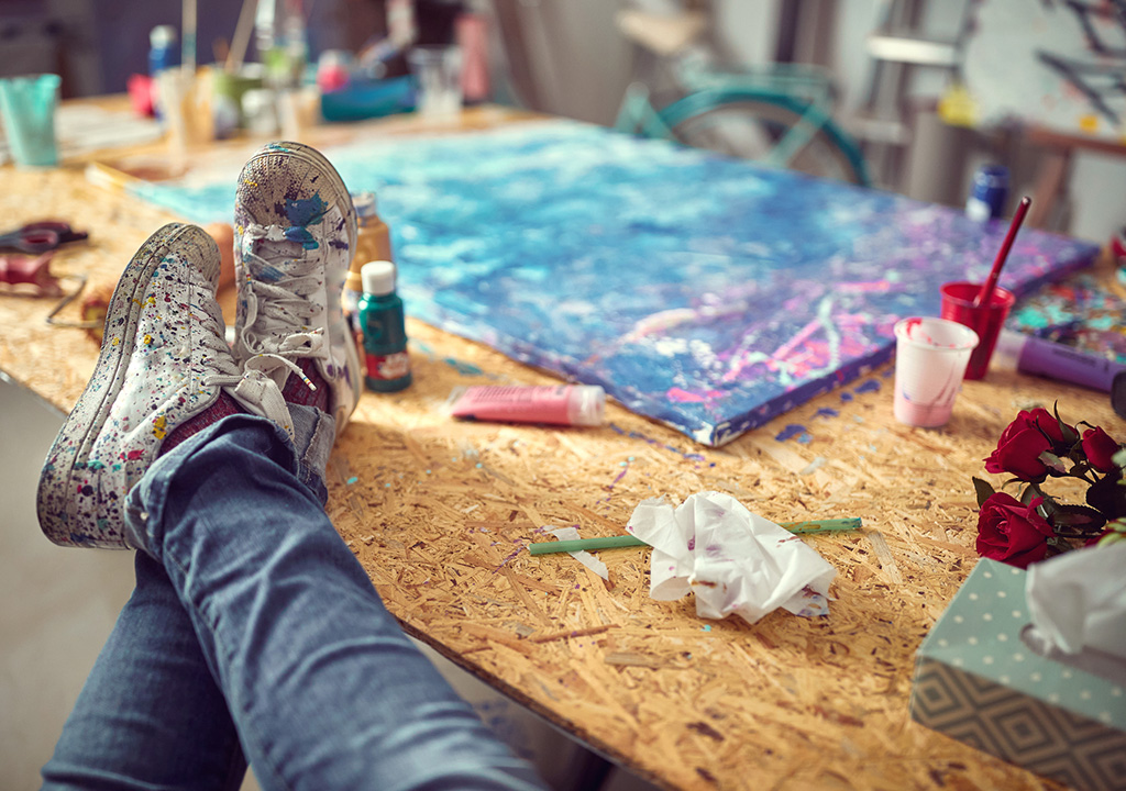 Female artist relaxing after completing a new piece in the studio