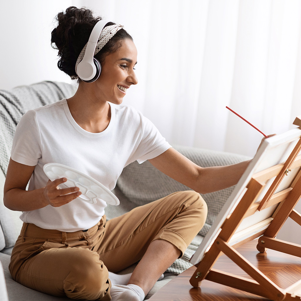 a woman relaxing while painting and listening to music