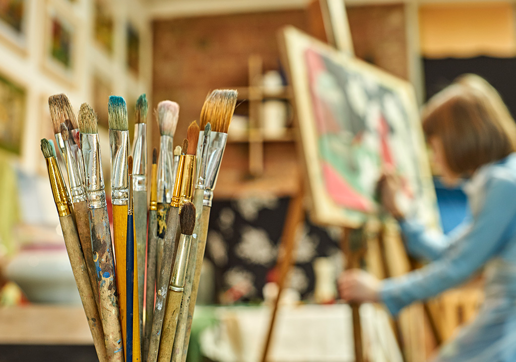 a woman painting in a studio